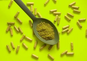 Kratom,Pills,Composition,On,Yellow,Background,With,Kratom,Filled,Spoon